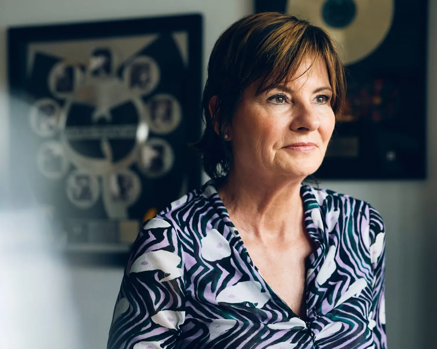 Porträt von Eva Ries, Speakerin und Kulturjournalistin, nachdenklich blickend in einem Arbeitsumfeld mit Musikbezug