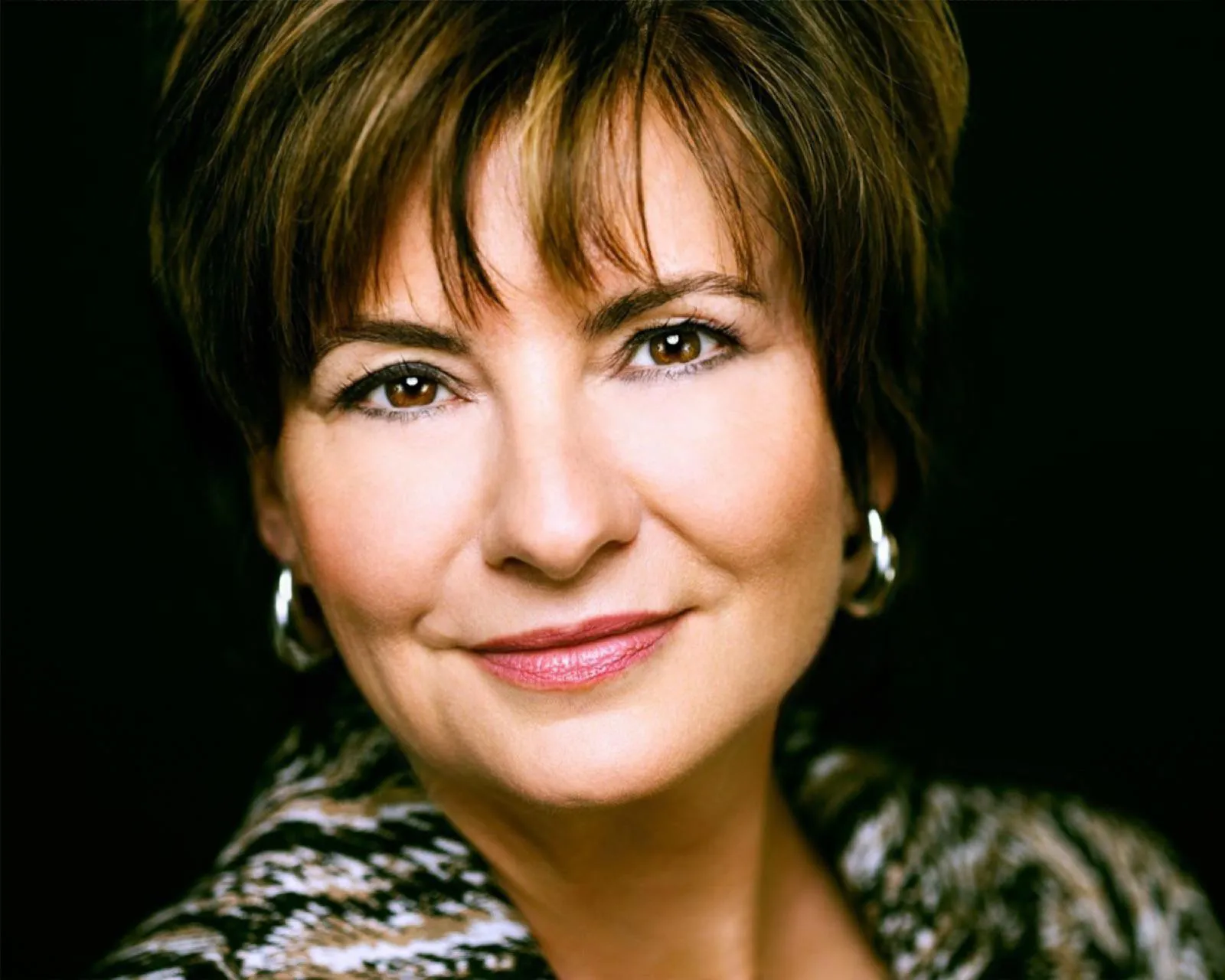 Eva Ries, Speakerin für Musikgeschichte und Popkultur, in ruhiger Nahaufnahme vor dunklem Hintergrund